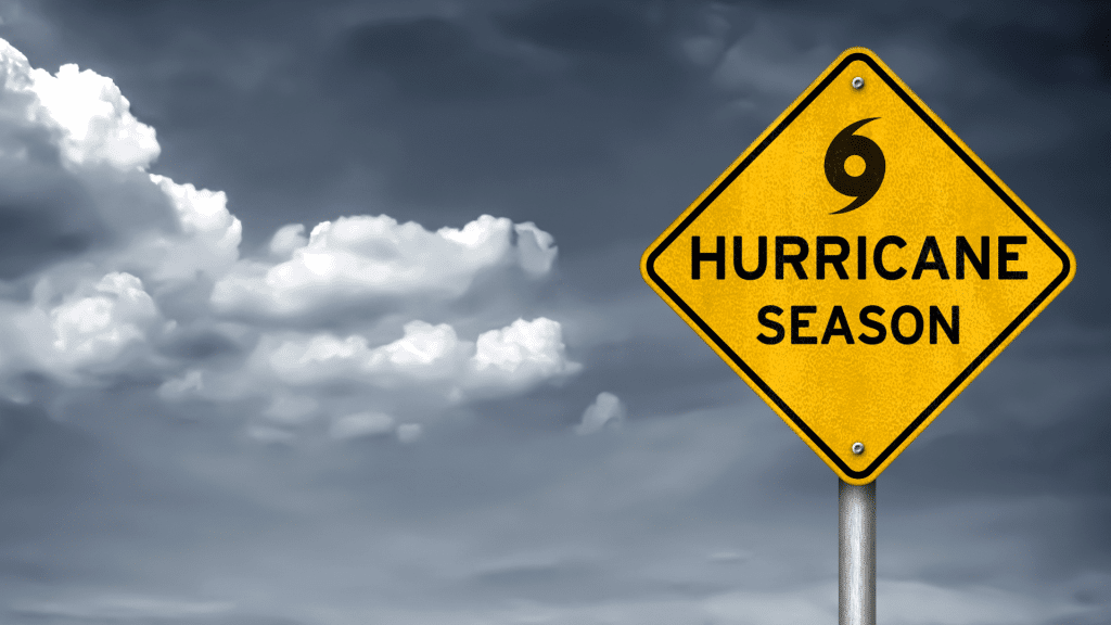a road sign that says "Hurricane Season" in front of dark clouds