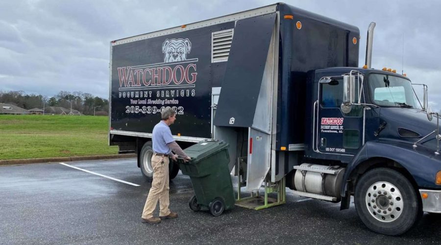 Watchdog Document Services employee loading bin of documents onto shred truck